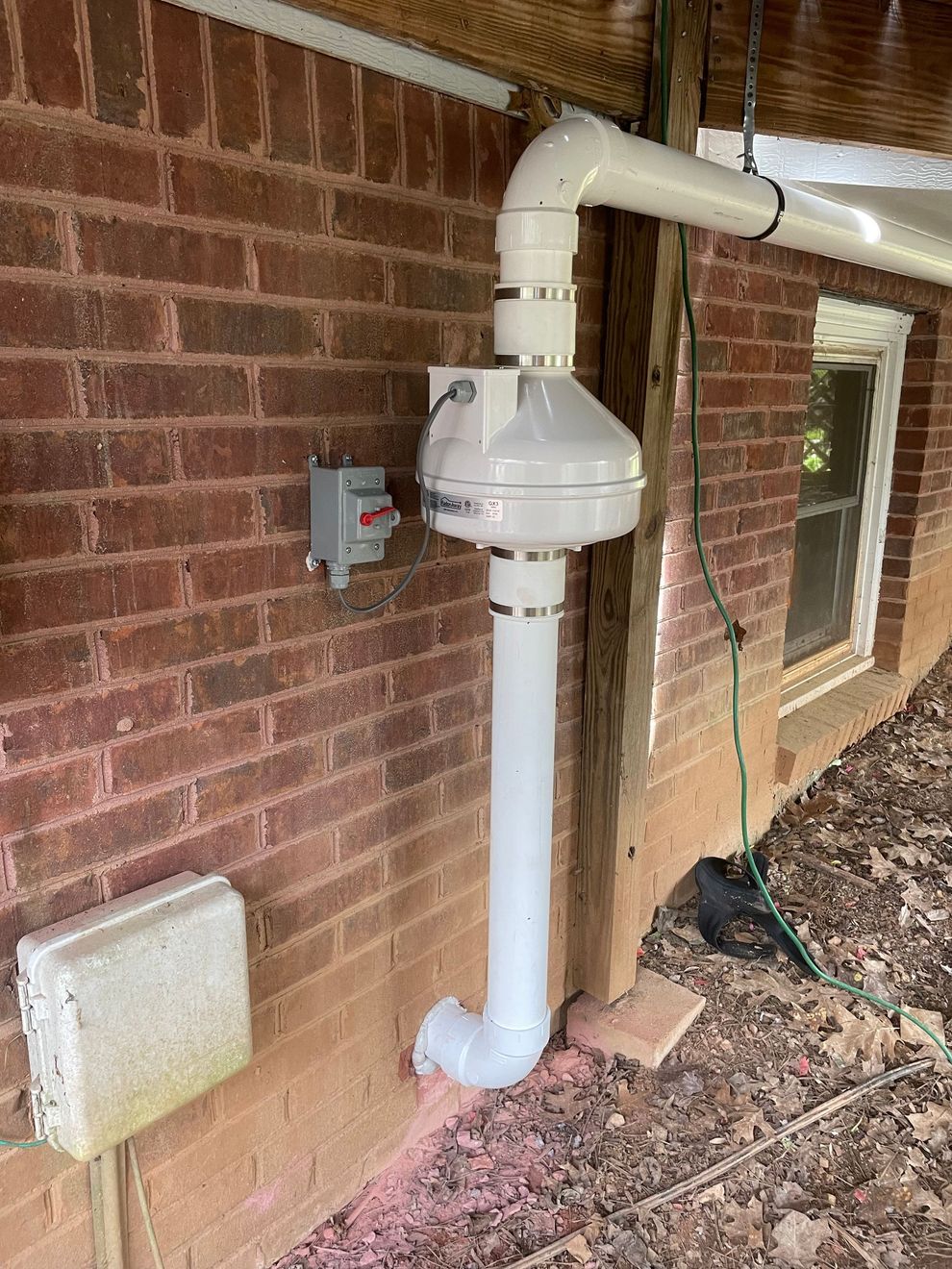 A White Pipe Is Attached to The Side of A Brick Building | Birmingham, AL | Cardinal Construction