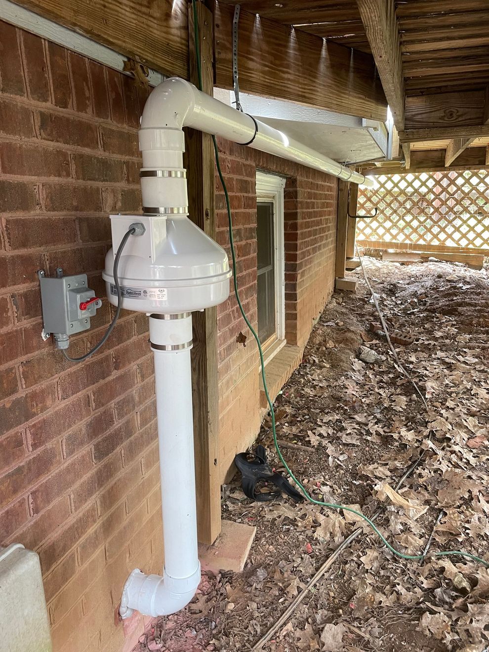 A White Pipe Is Attached to The Side of A Brick Building | Birmingham, AL | Cardinal Construction