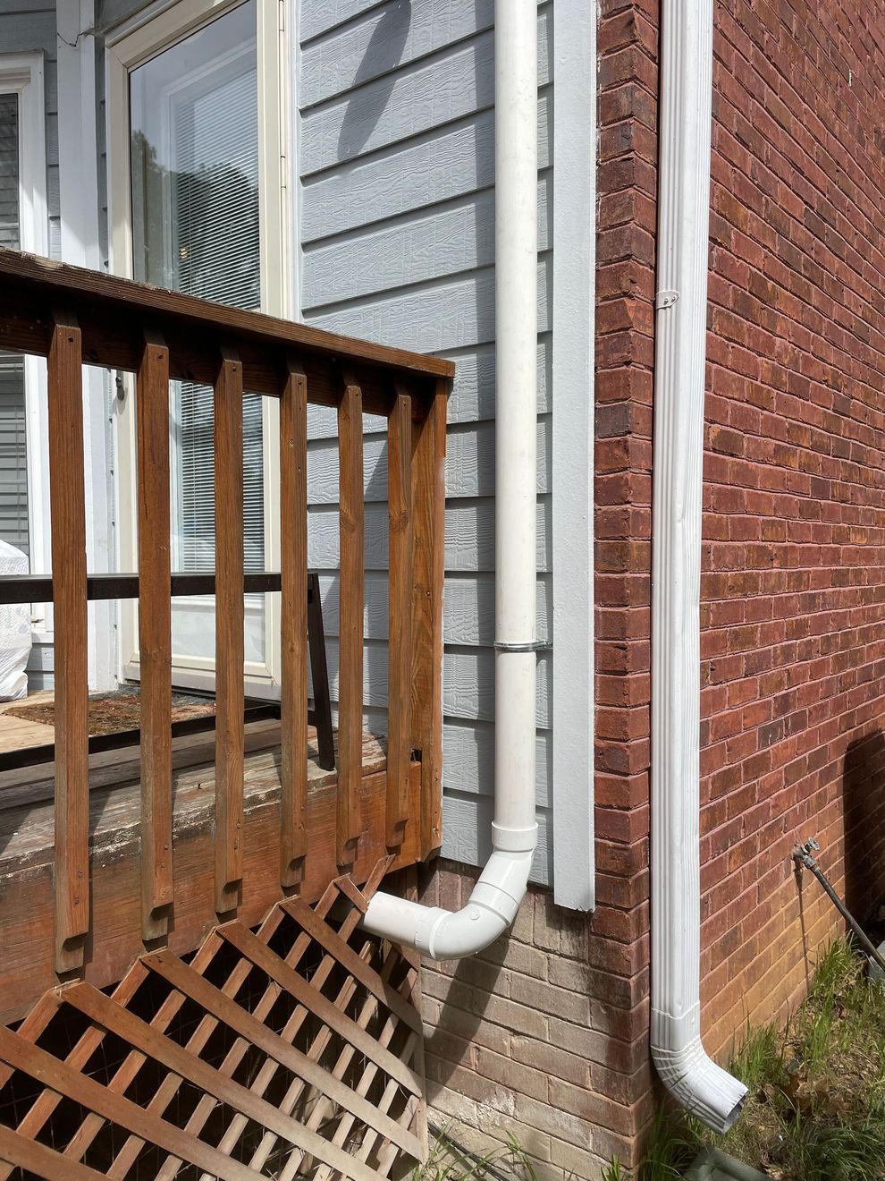 A White Drainpipe Is Attached to The Side of A Brick House | Birmingham, AL | Cardinal Construction