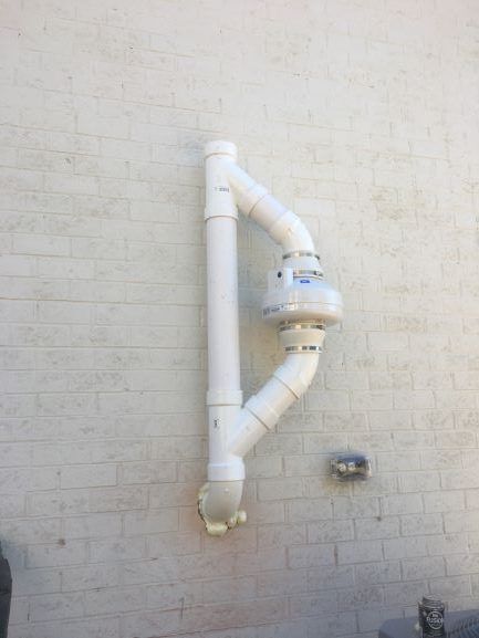 A White Pipe Is Attached to A White Brick Wall | Birmingham, AL | Cardinal Construction