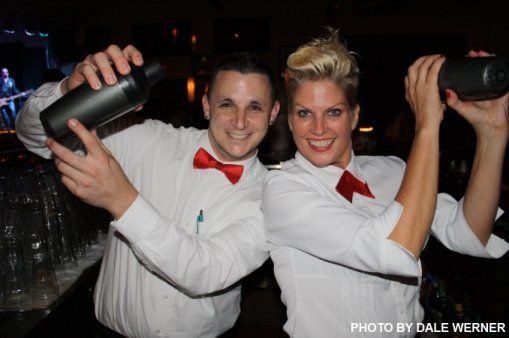 A man and a woman are posing for a photo while holding shakers