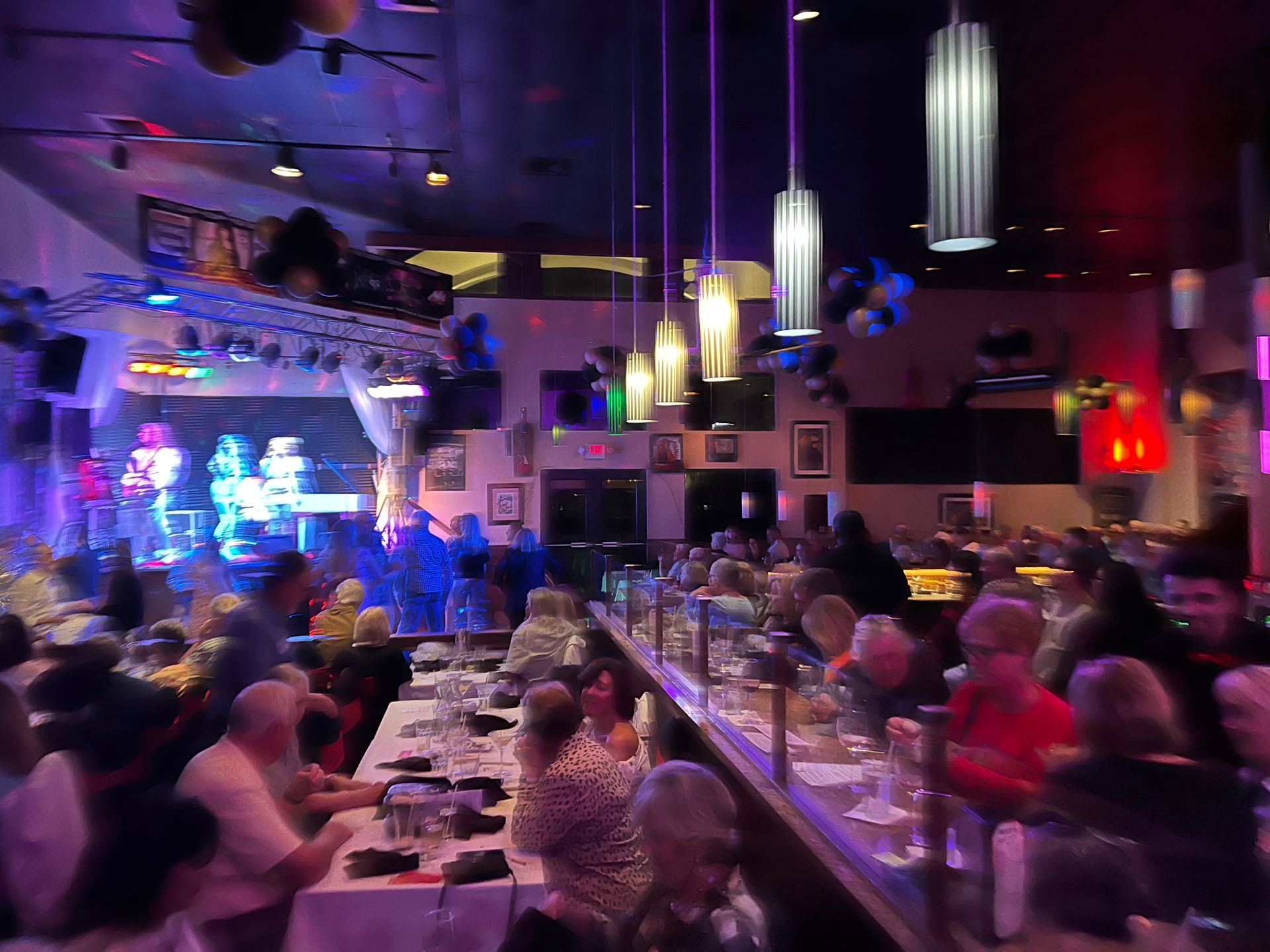 A crowd of people are sitting at tables in a restaurant