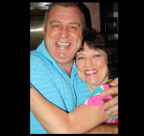 A man and woman are hugging and smiling for the camera