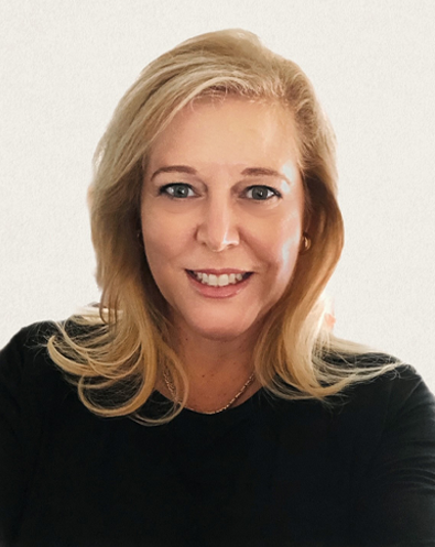 A woman with blonde hair is wearing a black shirt and smiling for the camera.