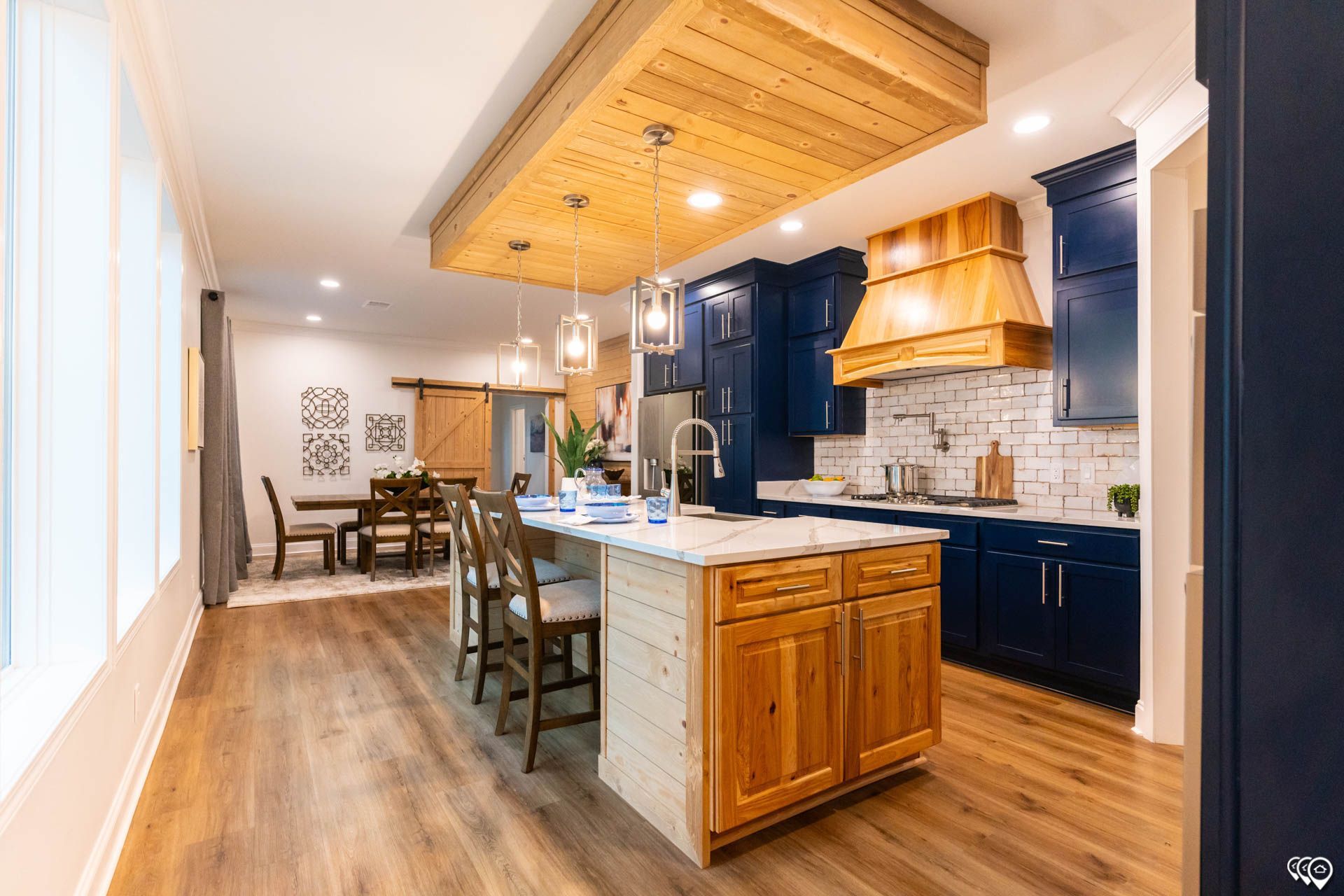 Modern kitchen with blue cabinets, wooden island, and dining area.