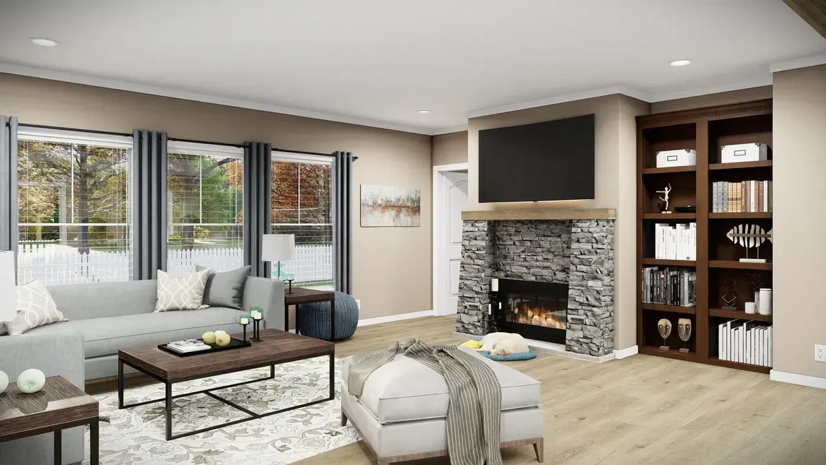 Cozy living room with fireplace, bookshelves, large windows, gray sofa, and ottoman.