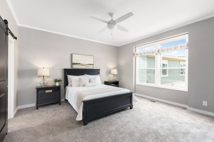 Bedroom with gray walls, dark furniture, and a large window.
