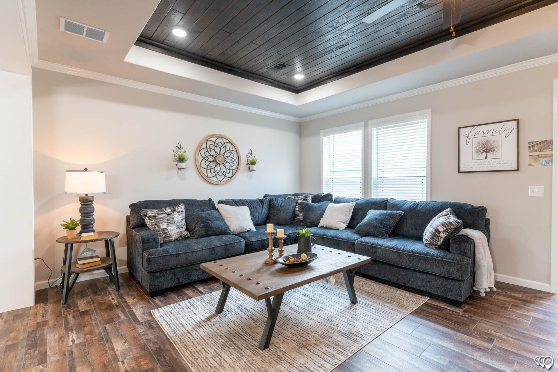 Living room with gray sectional sofa, wood coffee table, and dark ceiling.