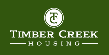 Logo for Timber Creek Housing, featuring a white emblem and text on a dark green background.
