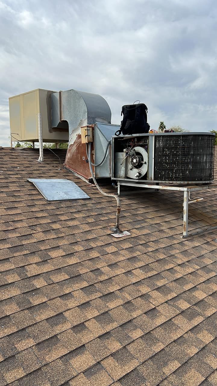An air conditioner is sitting on top of a roof.