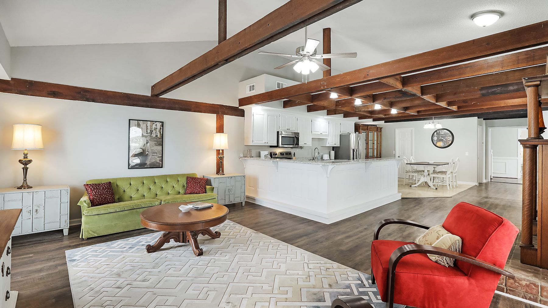 A living room with a green couch and a red chair.