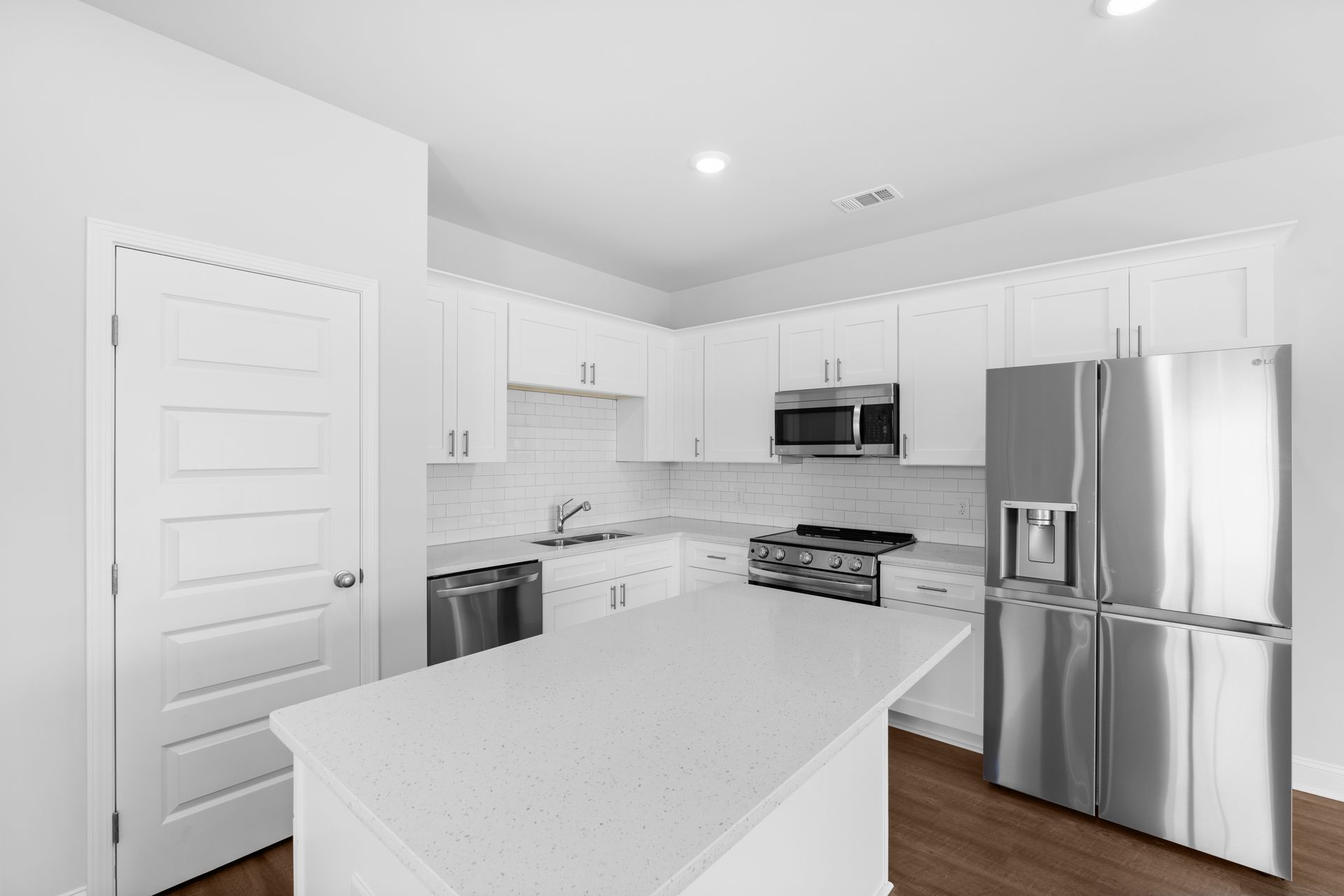 A kitchen with white cabinets and stainless steel appliances