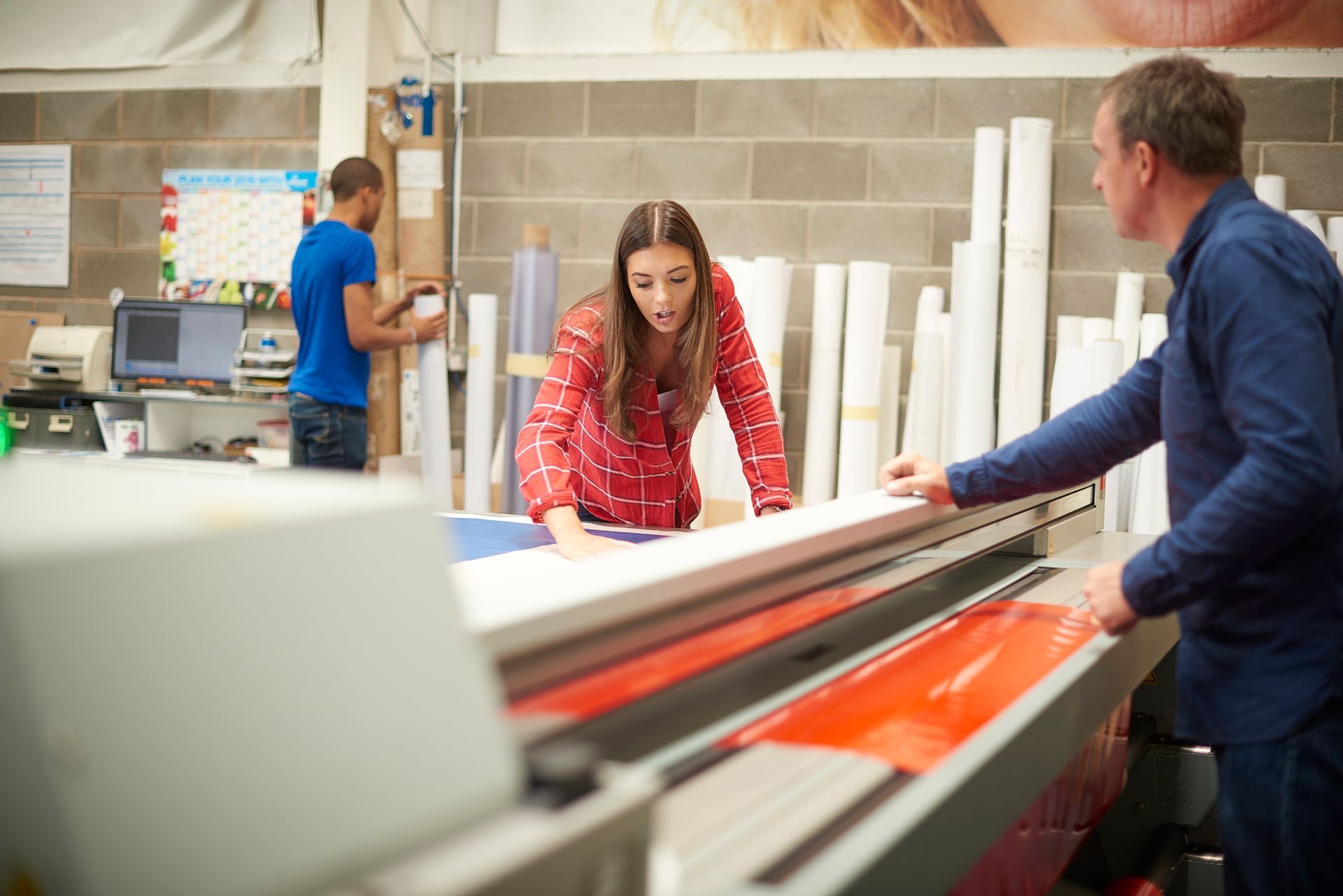 A young woman working on a digital printing machine.