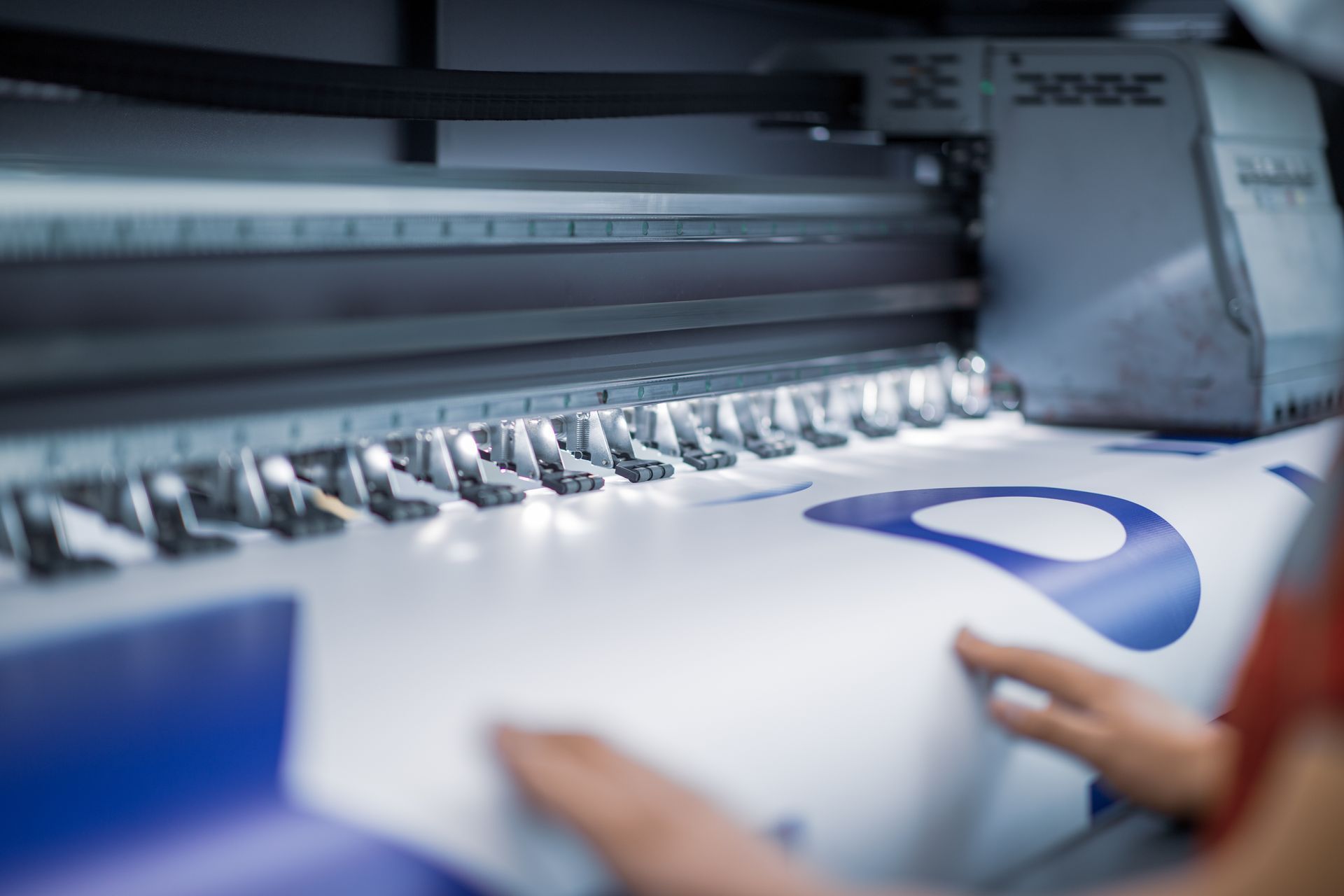 Close-up of a sign manufacturer using a printer.