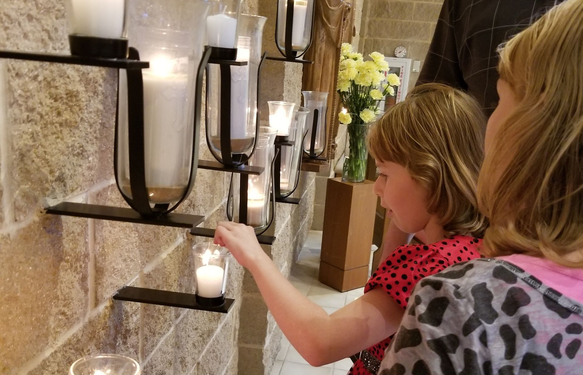 Why do Catholics light votive candles?