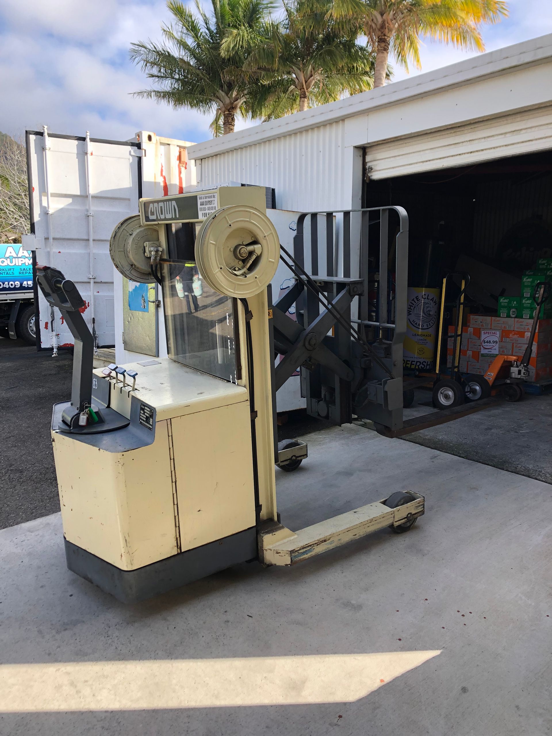 A different forklift waiting to outside a warehouse door— AAA Equipment Pty Ltd In Redbank, NSW