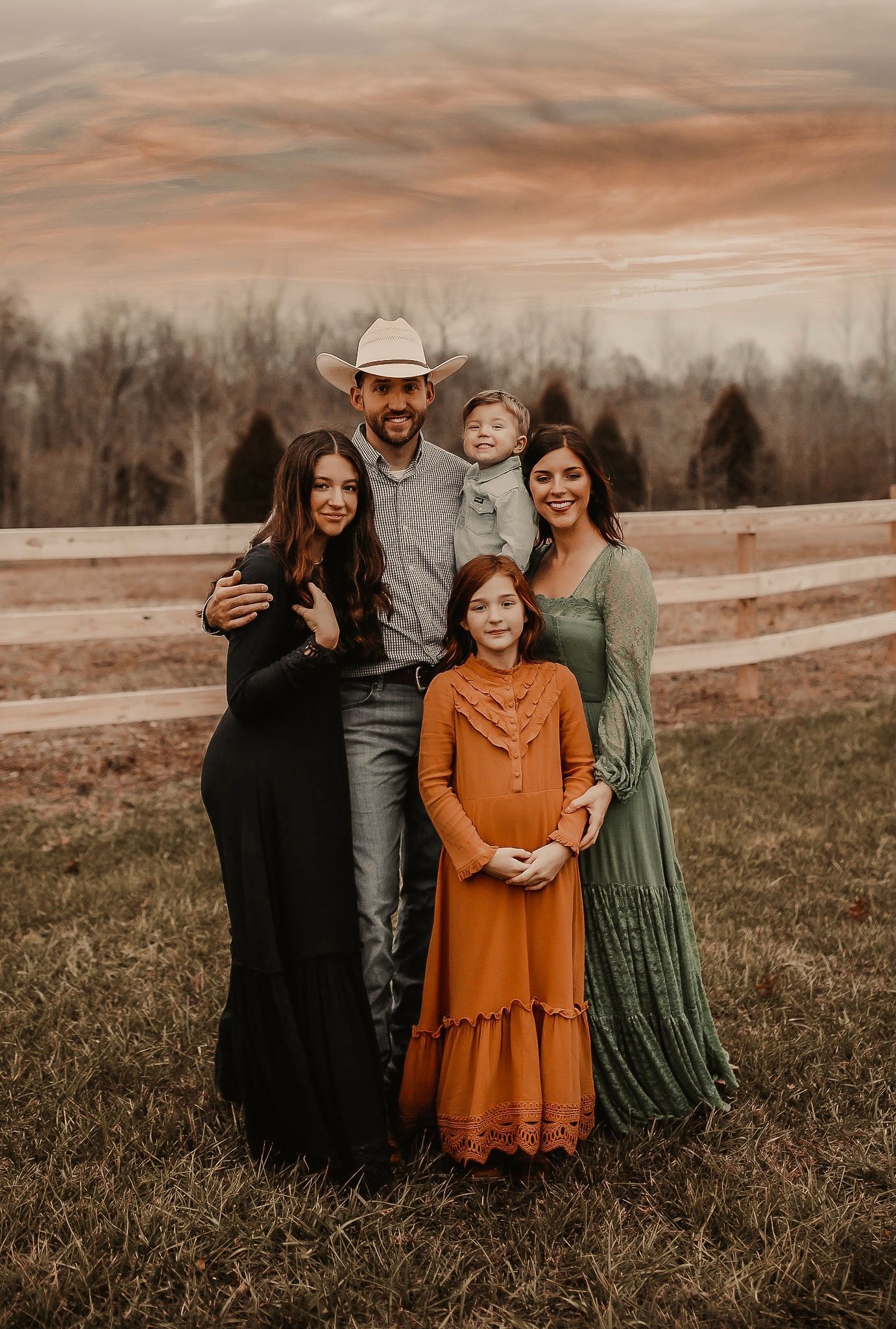 A family is posing for a picture in a field.