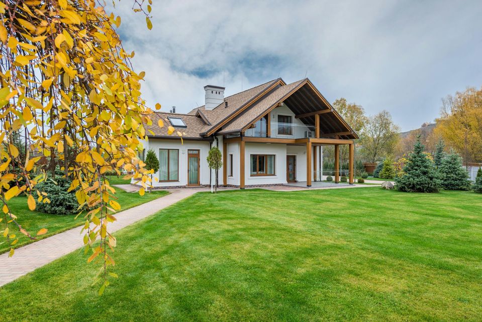 A large house with a lush green lawn in front of it.