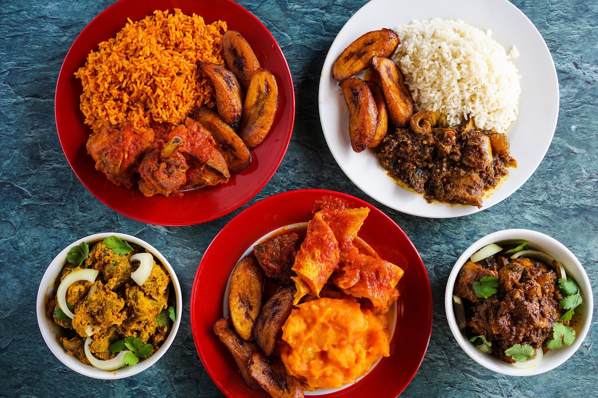 A man is sitting at a table eating food from plates.