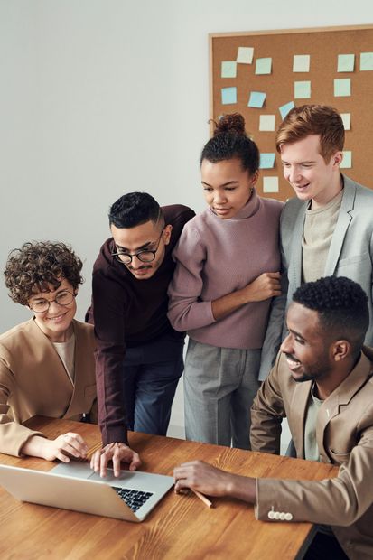 A group of people are looking at a laptop computer.