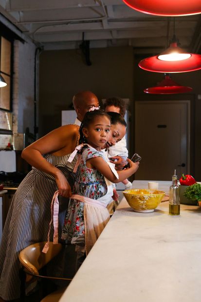 A woman is holding a little girl in her arms in a kitchen.