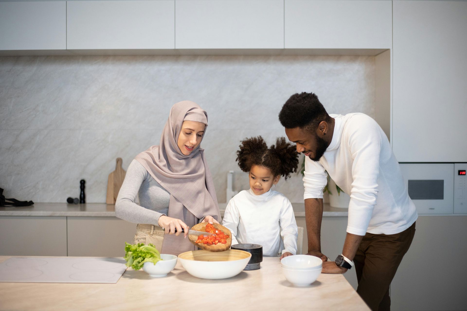 A family is preparing food together in a kitchen.