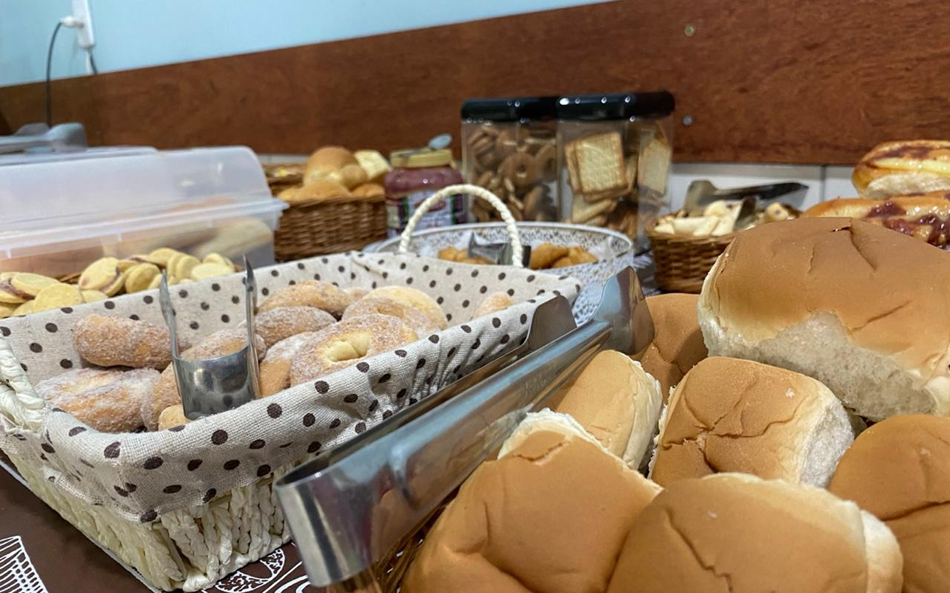 Variedade de produtos de panificação, incluindo pães e doces, dispostos sobre uma mesa.