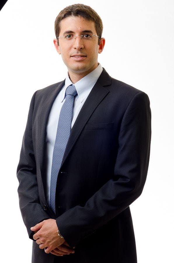 A man in a suit and tie is standing with his hands on his hips