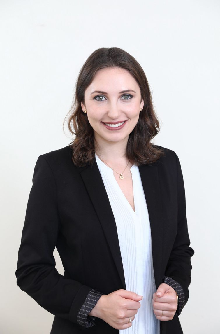 A woman is wearing a black jacket and a white shirt.
