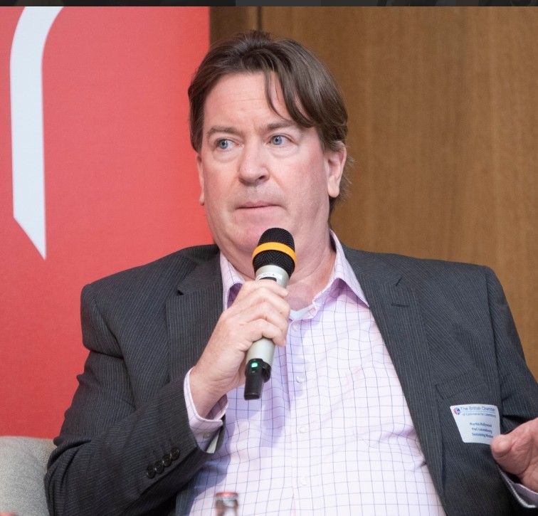 A man in a suit is holding a microphone in his hand