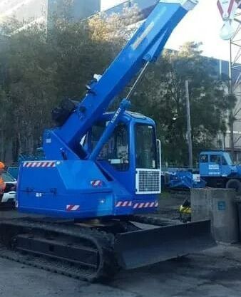 A Blue Crane is Parked in a Parking Lot Next to a Truck — Newcastle Cranes In Cardiff, NSW