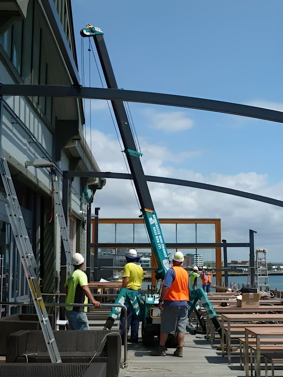 A Group Of Construction Workers Are Working On A Building — Newcastle Cranes In Cardiff, NSW