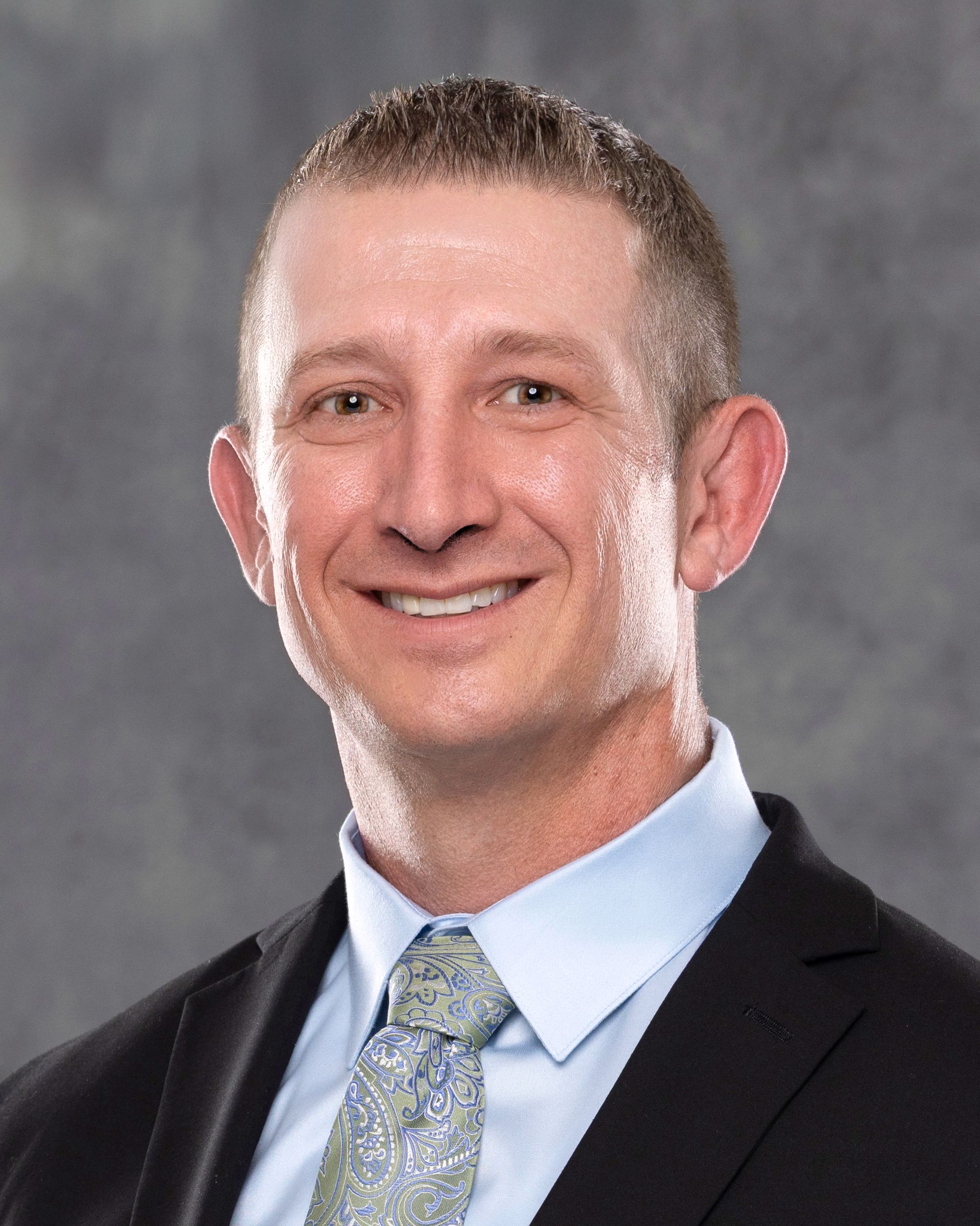 A man in a suit and tie is smiling for the camera.