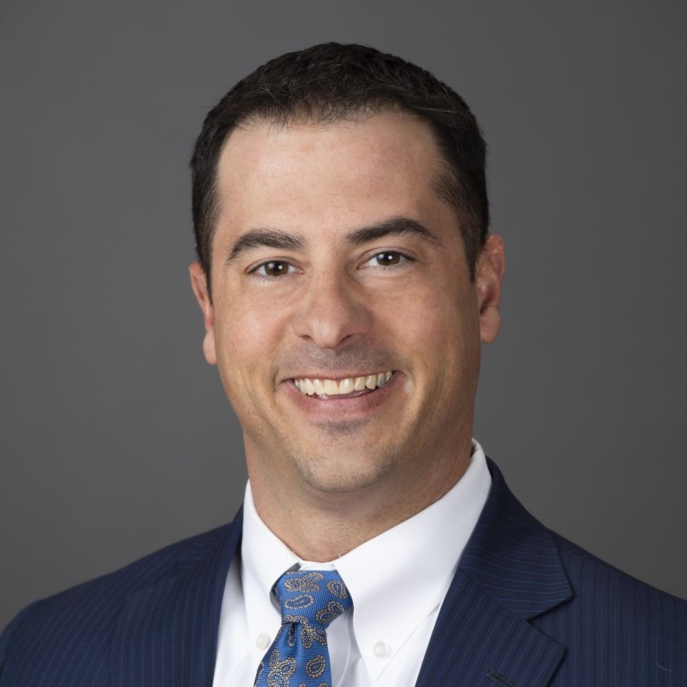 A man in a suit and tie is smiling for the camera.