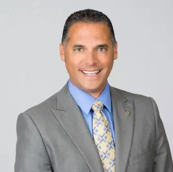 A man in a suit and tie is smiling for the camera.