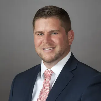 A man in a suit and tie is smiling for the camera.