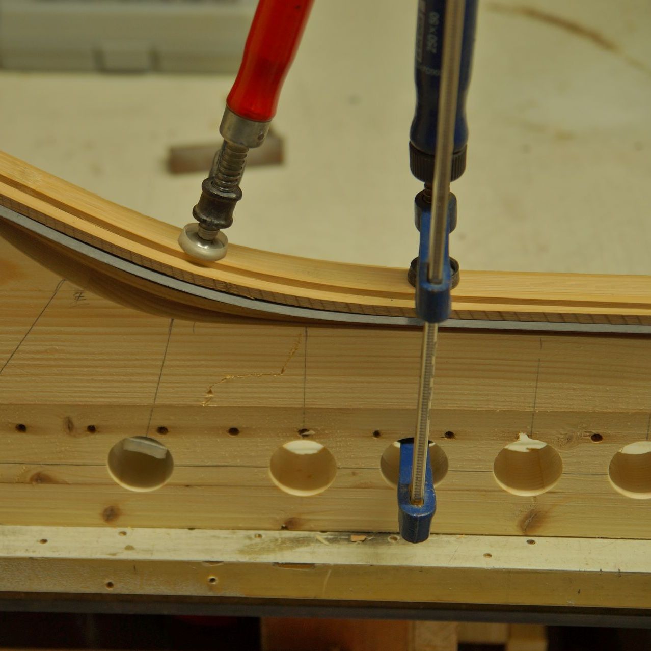 A piece of wood with holes in it is being glued together