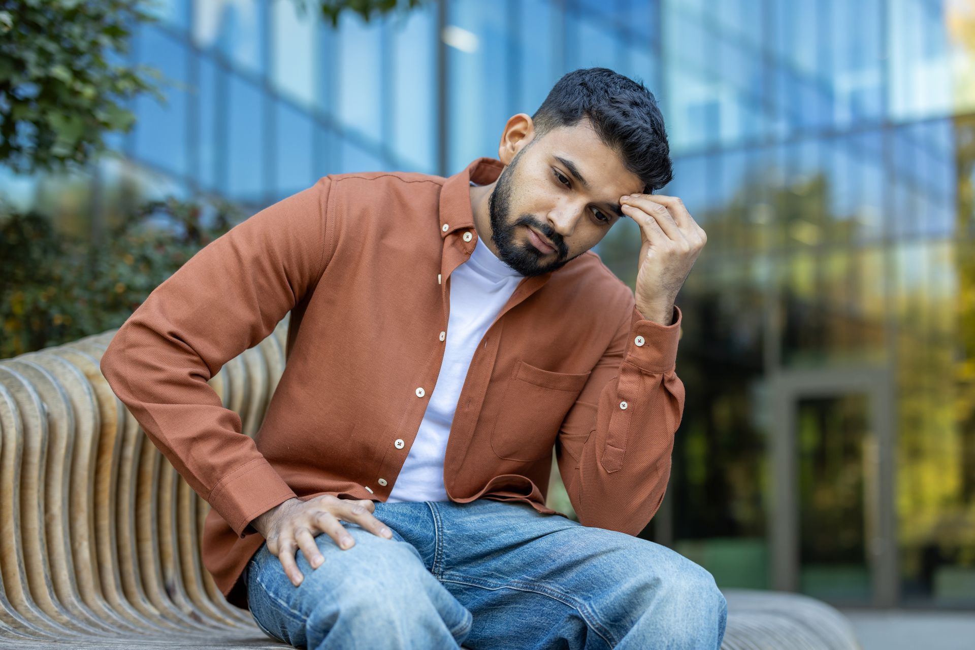 A woman is sitting on a bed holding a pillow.