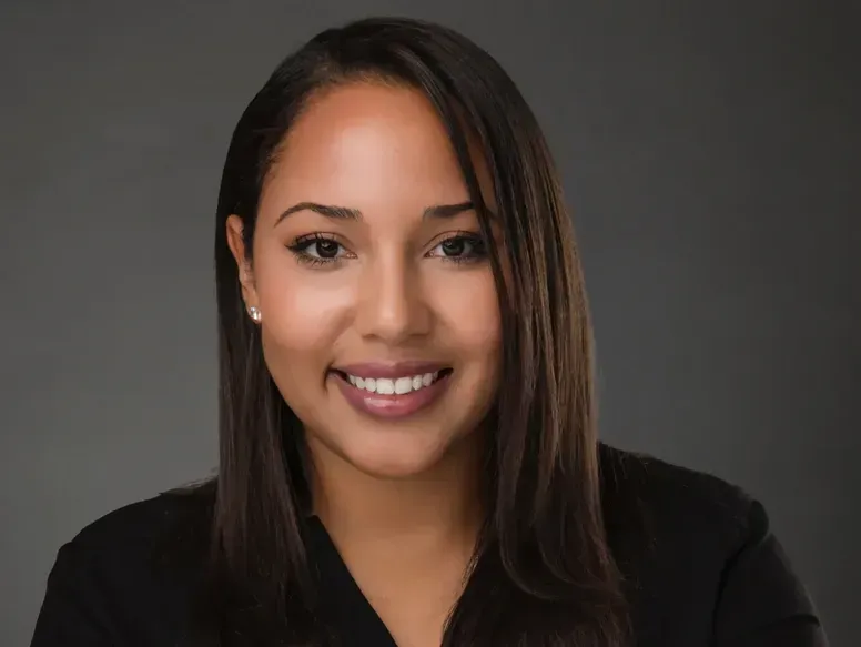 A woman in a black shirt is smiling for the camera.