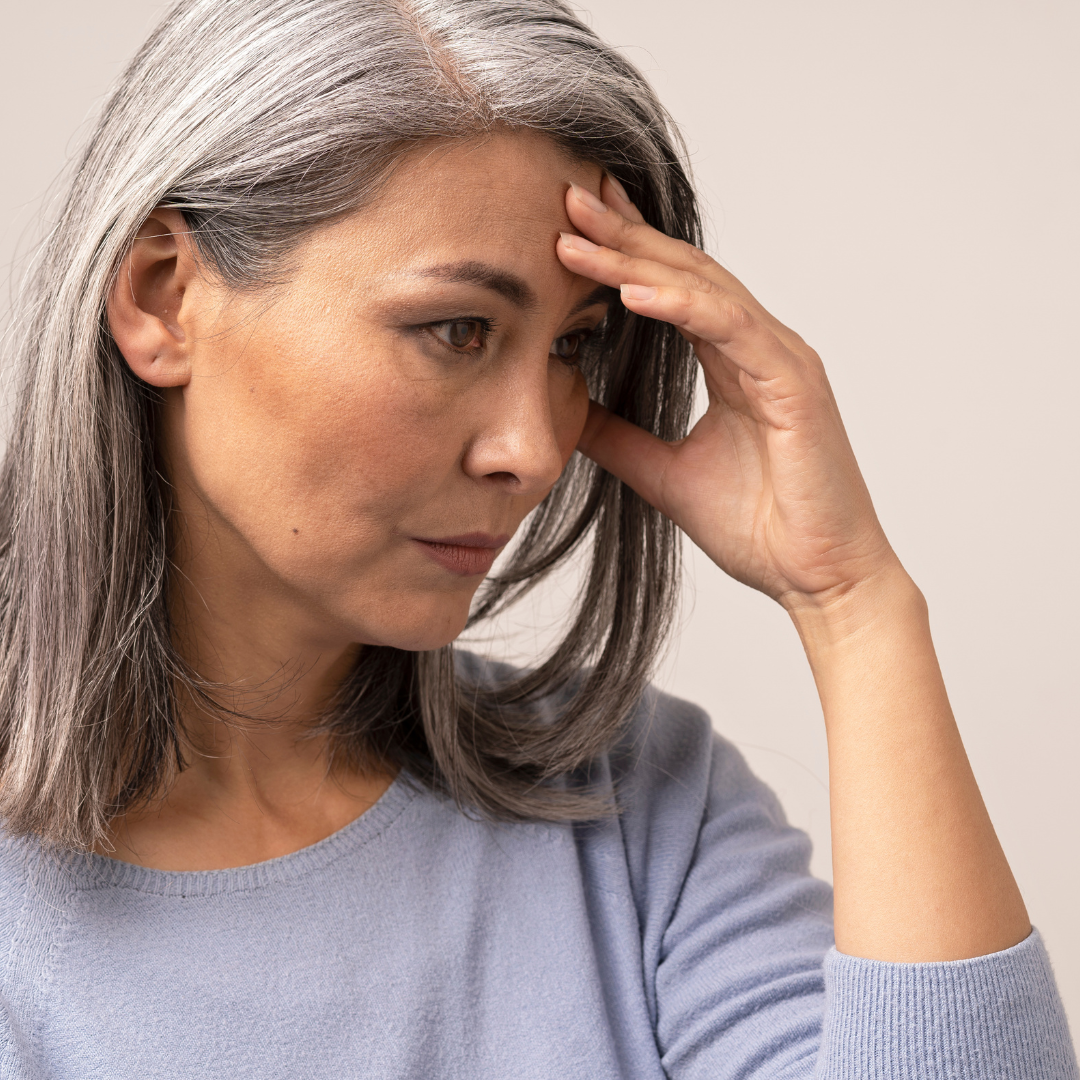 A man is sitting on an airplane looking out the window.