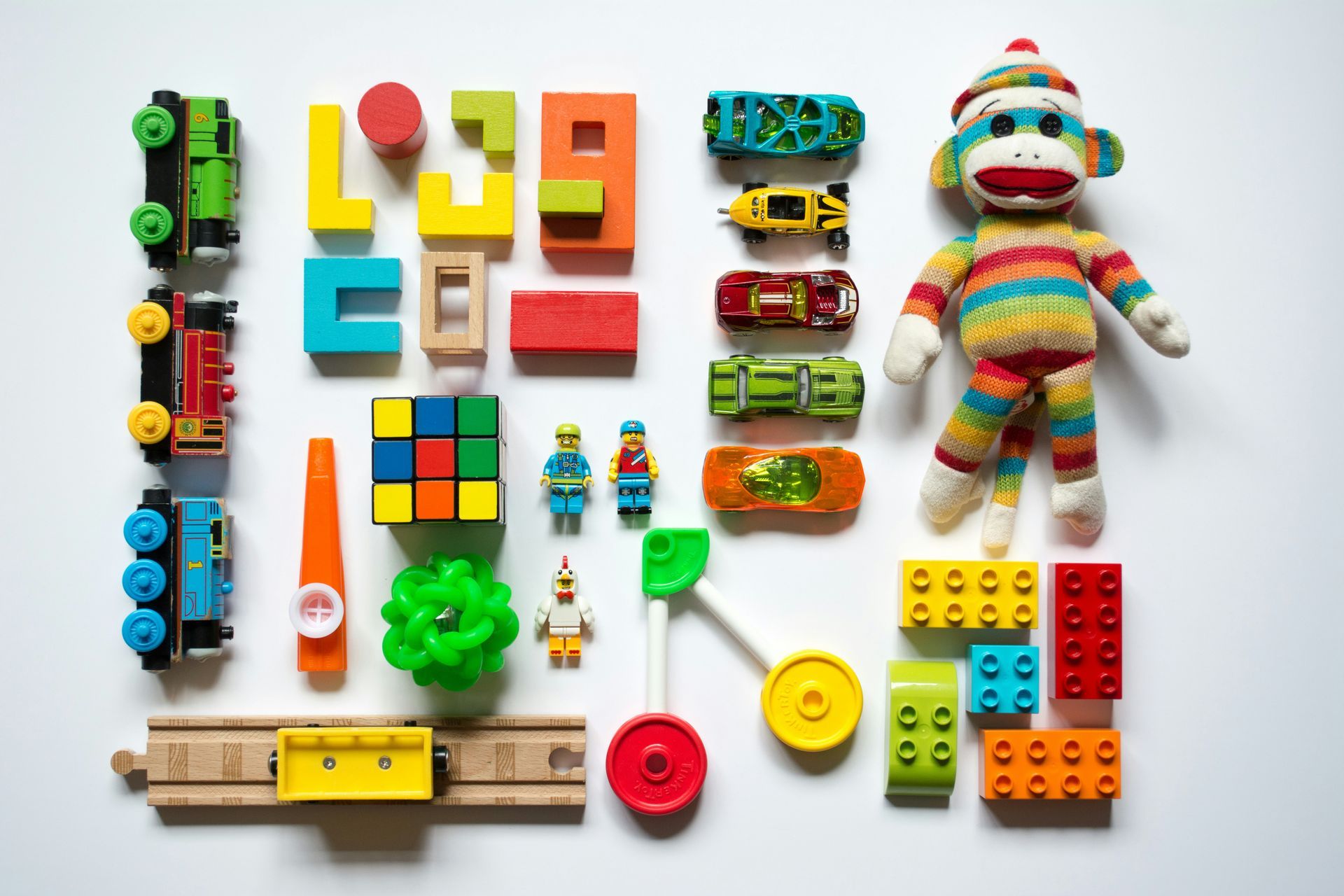 A monkey is sitting on top of a pile of toys.