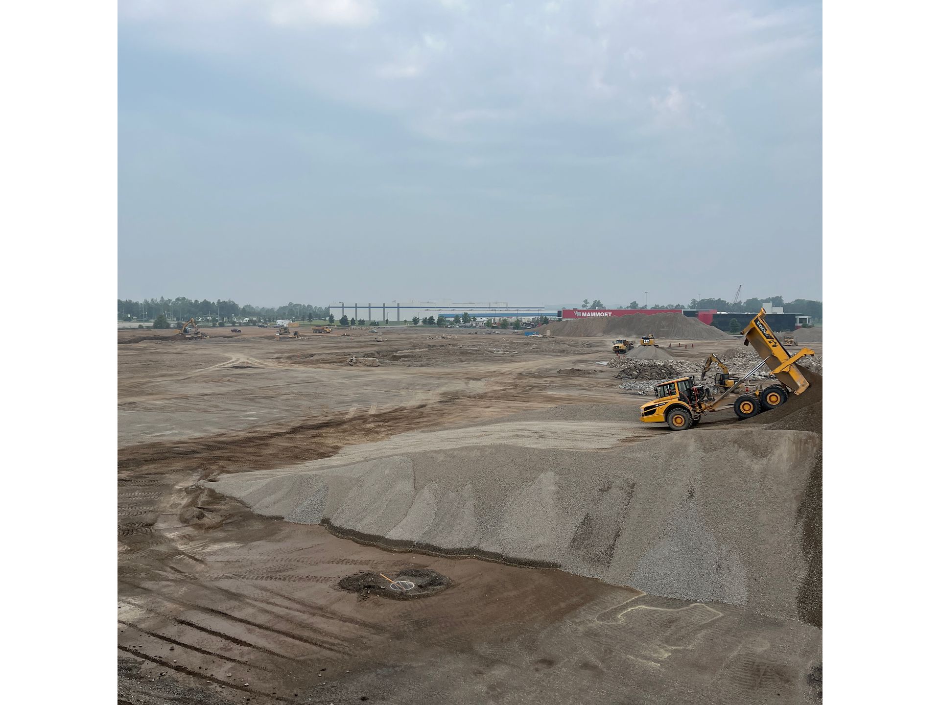 A large pile of dirt is being loaded into a dump truck.