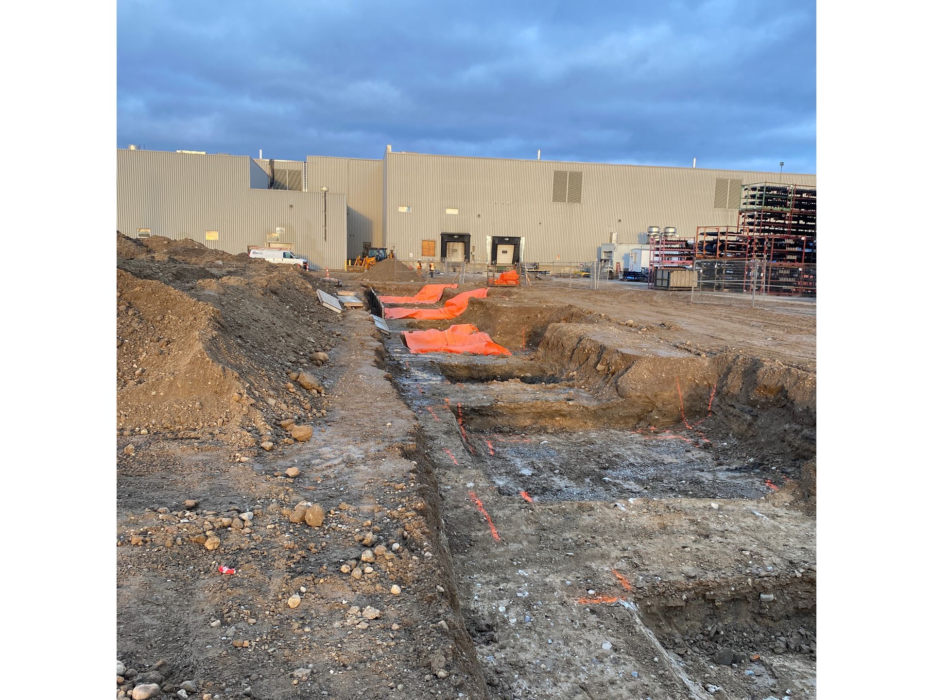 A construction site with a large building in the background.