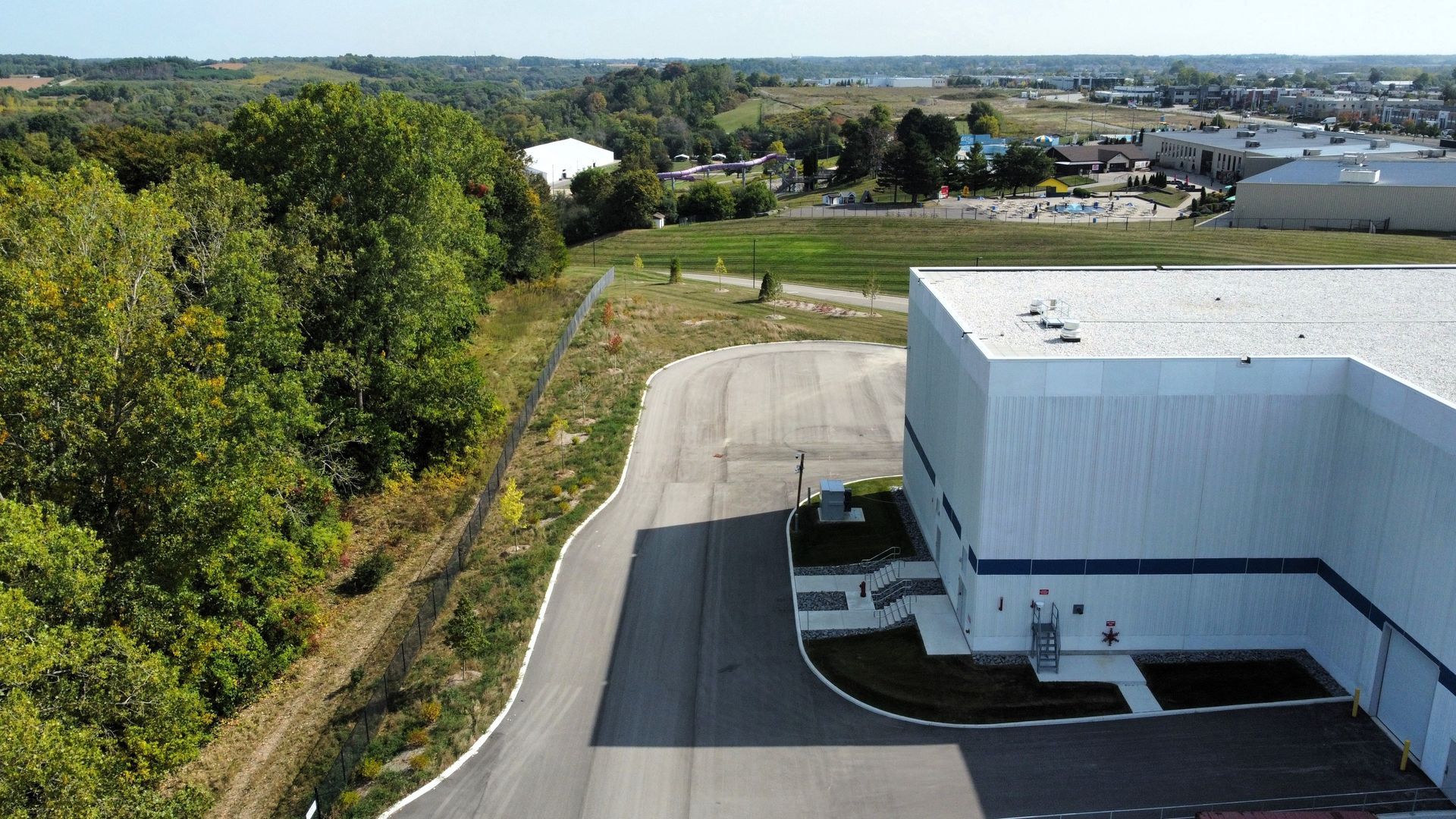 An aerial view of a large white building surrounded by trees.
