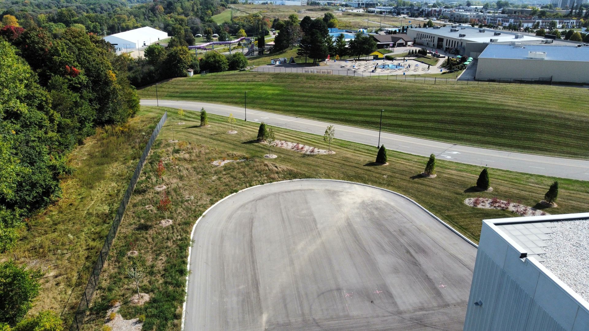 An aerial view of a curvy road with a building in the background.