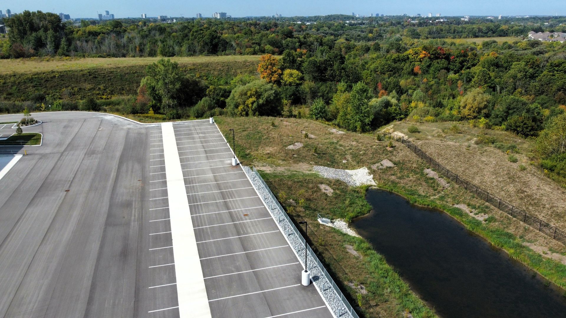 An aerial view of a parking lot with a river in the background.