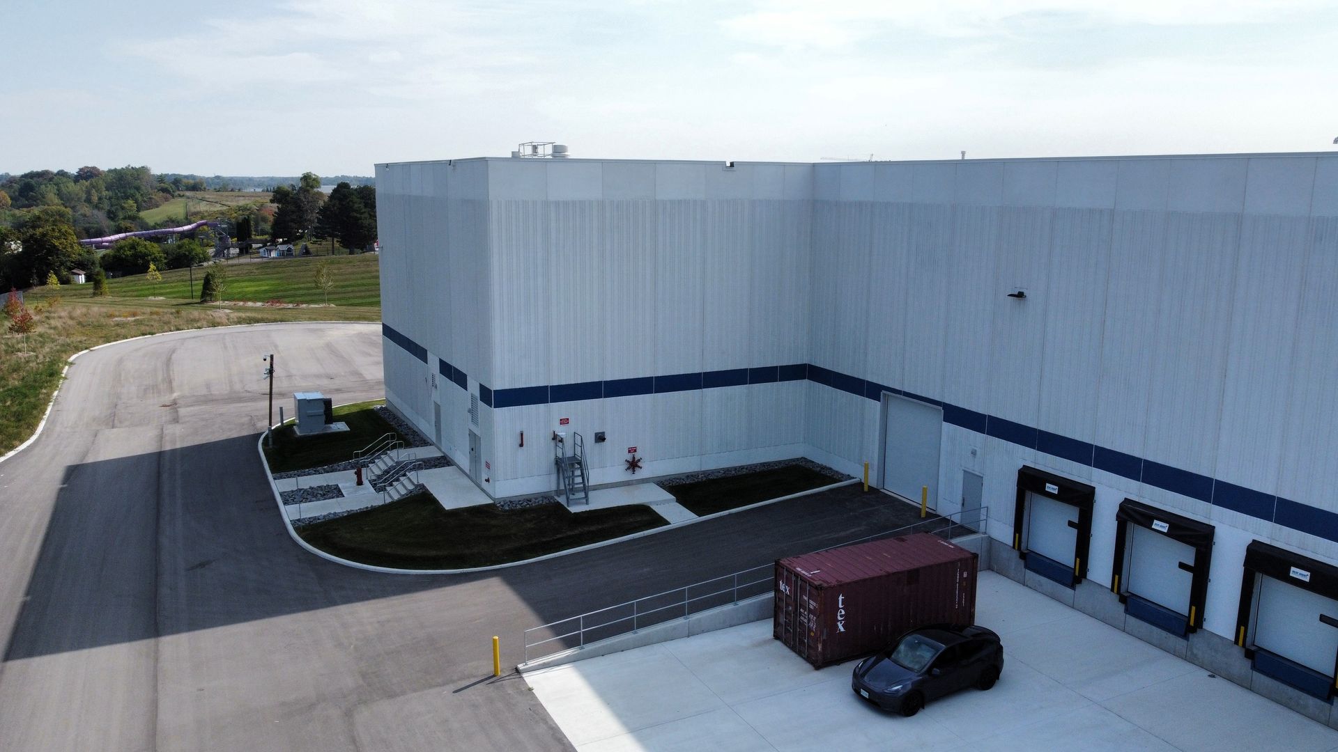 An aerial view of a large building with a car parked in front of it.