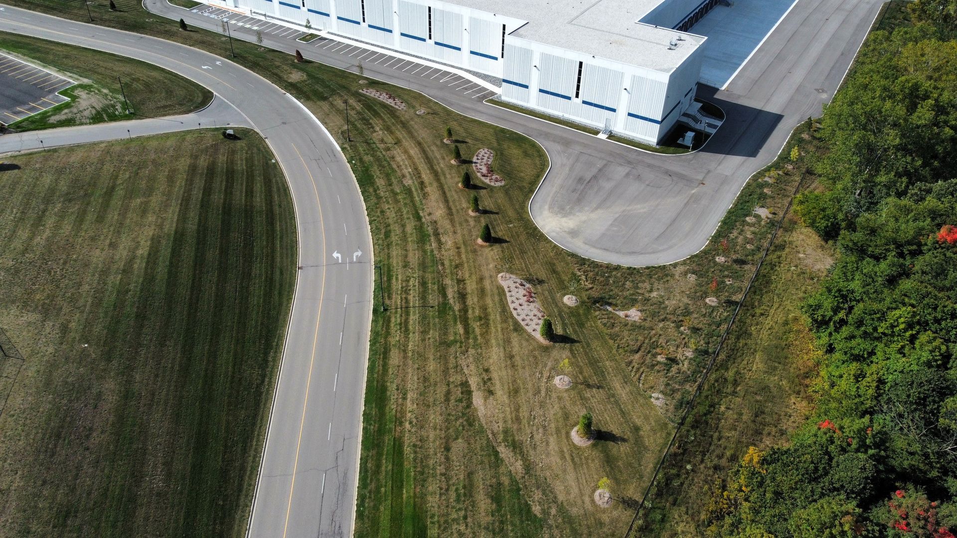 An aerial view of a road leading to a large building.