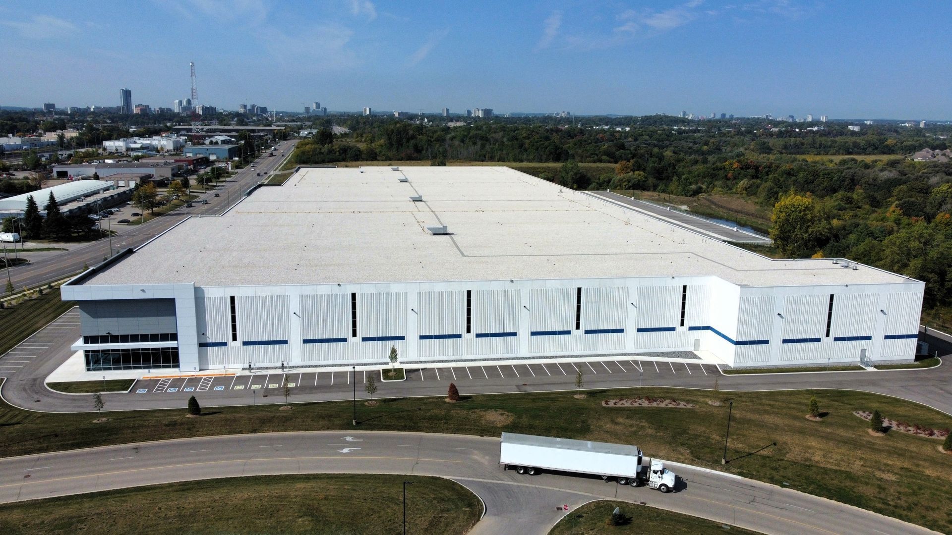An aerial view of a large white building with a truck parked in front of it.