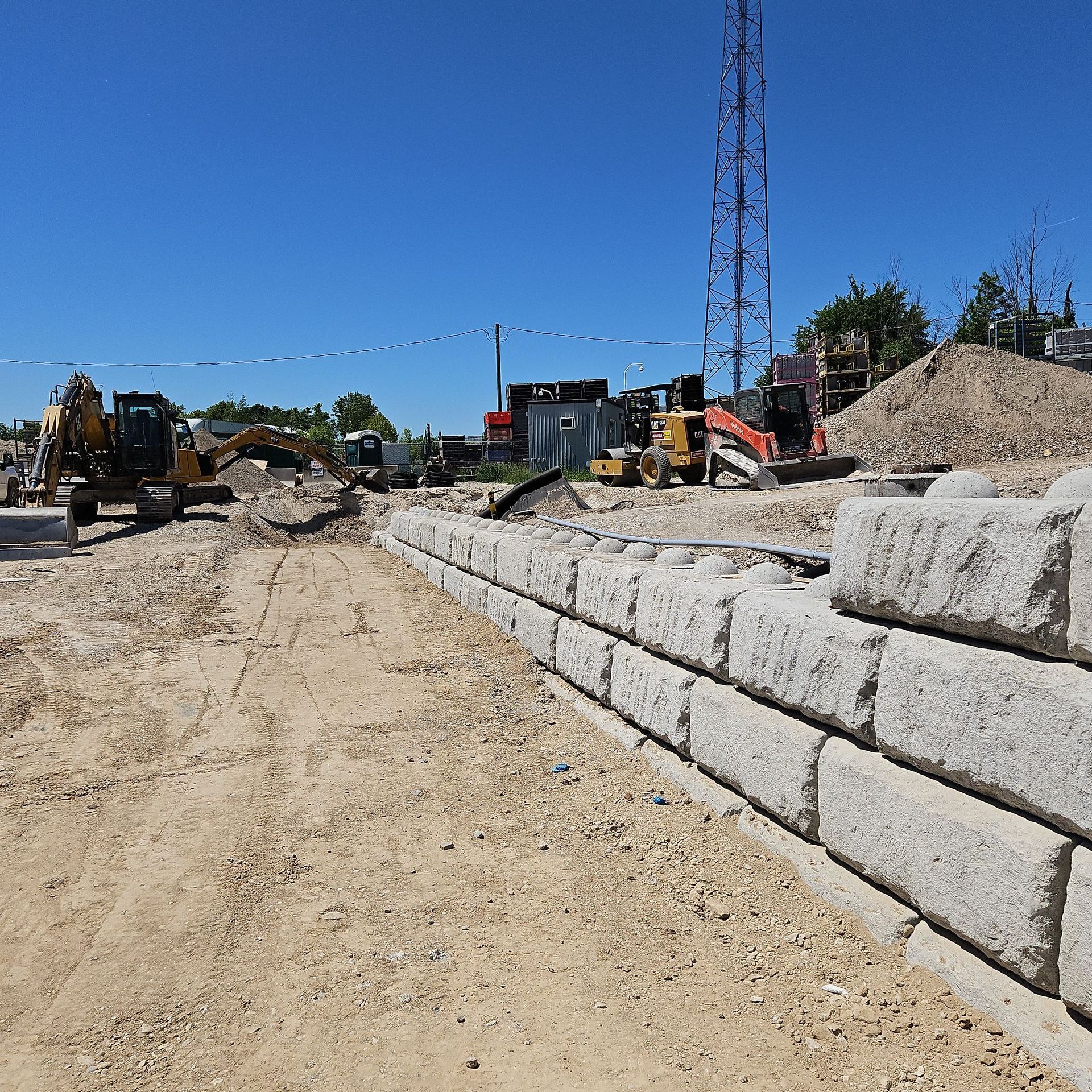 A concrete wall is being built on a dirt road